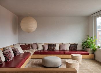 a living room with a red couch and a large window